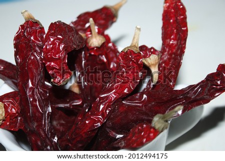 Dry Red Chilies, ripe, spicy dried Anaheim pepper. Close Up picture and wooden background.