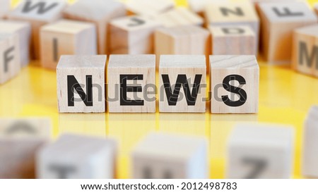 the word news is written on a wooden cubes structure. blocks on a bright background. financial concept. selective focus.