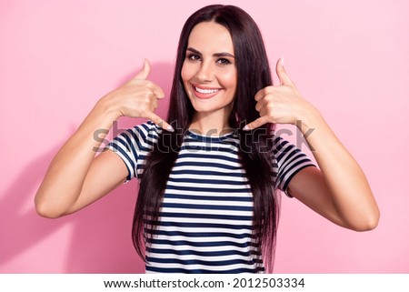 Photo of cheerful nice pretty young woman make call me back gesture line isolated on pastel pink color background
