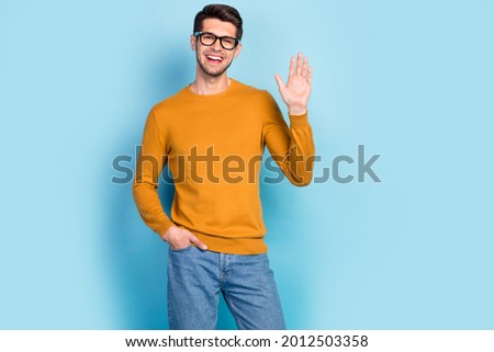 Photo of young cheerful man happy positive smile waving hand hello hi greetings isolated over blue color background Royalty-Free Stock Photo #2012503358