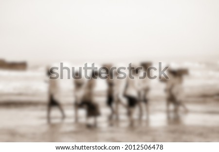 blur effect. a group of men and women who after carrying out religious celebrations in Tanah Lot Bali by crossing the sea to land.  one of the favorite tourist places to visit in Bali