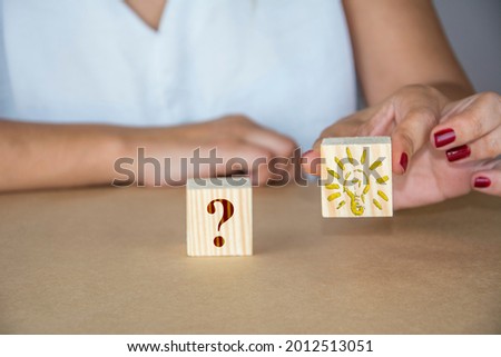 Unrecognizable woman highlights wooden cube with idea symbol