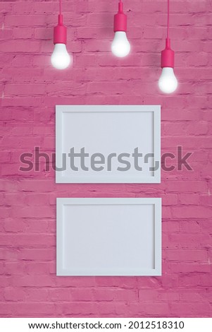 Mock-up two frames on a pink brick wall with light bulbs. Insert your text or image. Vertical format