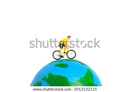 Miniature people toy figure photography. World bicycle day or tour around the world concept. A biker cycling above earth globe, isolated on white background. Image photo