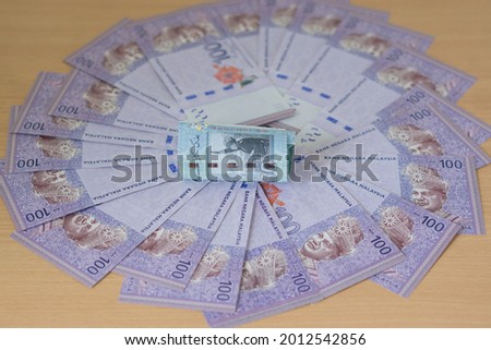 Malaysia ringgit banknotes. One hundred notes nicely arranged on the table. 