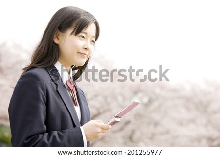 A middle school girl check her email with a mobile phone