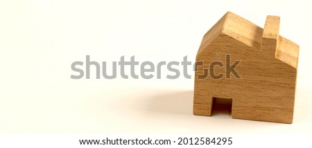 Model of a wooden house on a white background for planning to buy and sell a house.