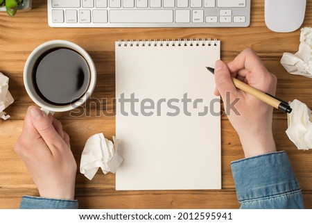 Overhead photo of blank notepad paper hands pen plant keyboard computer mouse and cup of coffee isolated on the wooden backdrop