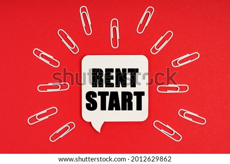 Business and finance concept. On a red background are paper clips and a sign with the inscription - RENT START
