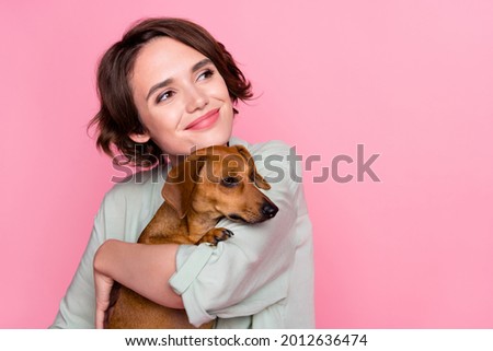 Photo of nice millennial lady hug dog look empty space wear grey green jacket isolated on pink color background