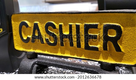 View of the metal plate with wording - 'Cashier' on the desk.