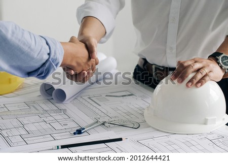 Shaking hands of collaboration, Construction engineering or architect discuss a blueprint while checking information and conference new project plan , contract , success, partnership concept. Royalty-Free Stock Photo #2012644421