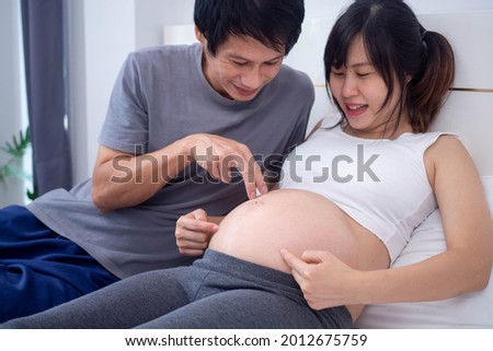 The husband was happy to play with the children in his wife's womb. wife can get pregnant 5 months are excited to see you baby.