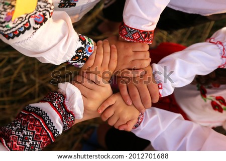 The hands of children in embroidered shirts are intertwined in a welcoming gesture. The united hands symbolize unity. Independence Day of Ukraine, Constitution, Embroidery Royalty-Free Stock Photo #2012701688