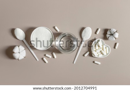 Collagen powder and pills on a beige background. plant or fish based collagen supplement. Healthy lifestyle concept. Copy space, top view, flat lay.