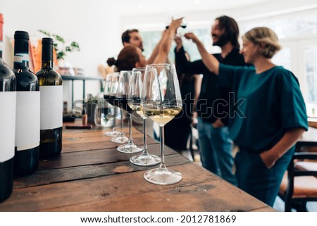 people inside a bar chilling out with a drink - friends talking and drinking in a winery - Millennials toasting at a wine tasting Royalty-Free Stock Photo #2012781869