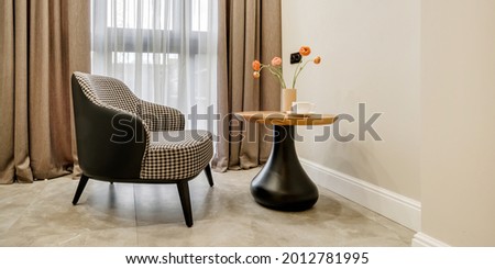 decor elements of the guest room and rest room with a tea table, an armchair and a bouquet of flowers and a cup of coffee 
