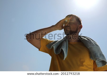 Man with towel suffering from heat stroke outdoors Royalty-Free Stock Photo #2012793218