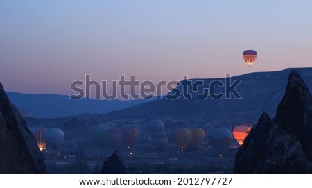 Hot air baloons preparing for take off. Famous sightseeing Cappadocia. Lights of air balloons. Royalty-Free Stock Photo #2012797727