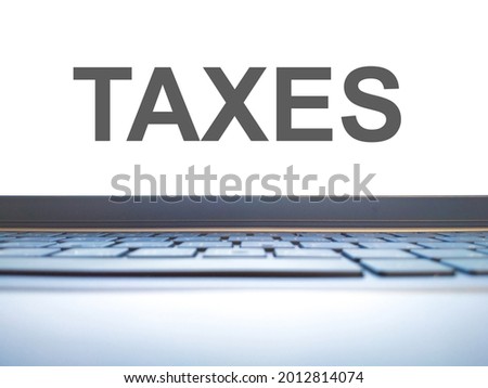 Taxes - financial text on the screen of an office computer. Tax payment concept