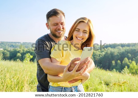 Beautiful happy adult couple taking selfie on smartphone