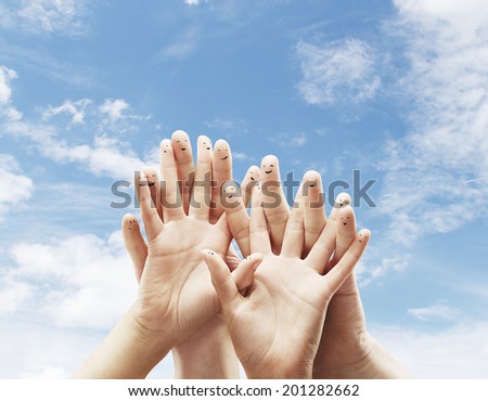 Happy group of finger smileys on sky background