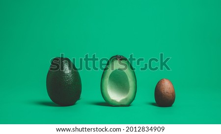 Horizontal Photo of Food Art with Avocados Cut in Half Put in a Row with a Green Background.