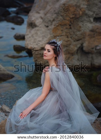 a beautiful woman like a fairy or nymph walking in the park. fairy tale image art photo. nymph of sea breathing ocean fresh air
