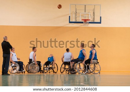 disabled war veterans in action while playing basketball on a basketball court with professional sports equipment for the disabled