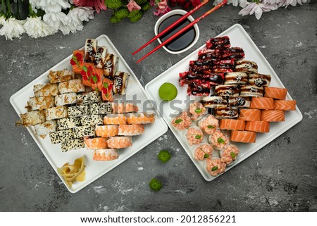 Japanese cuisine. Rolls in plates on a concrete background. Nets with salmon, eel
