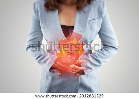 Acid reflux disease symptoms or heartburn, illustration stomach burn on woman's body against gray backgroundd, Concept with healthcare and medicine Royalty-Free Stock Photo #2012881529