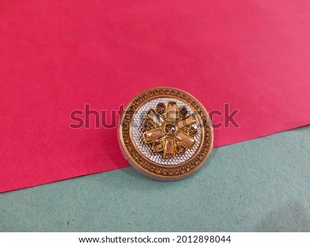 Attractive saree brooch on a colored paper background.