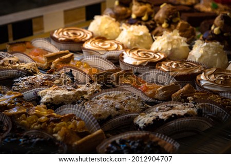 French traditional pastries from local organic ingredients on display in healthy lifestyle oriented patisserie. France. Sweet retro background. Difficult choice, indulgence concept. Low key photo Royalty-Free Stock Photo #2012904707