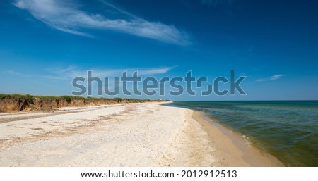 Long big beach near the sea. Seascape. Beautiful Black Sea. Blue sky with white clouds