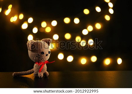 Handicraft,knitting,little cat with red bow on the table