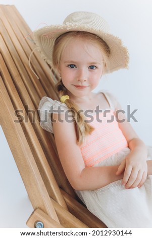 Adorable blondie cute little blondie girl in hat, smile on white background. Childhood, happy kid concept
