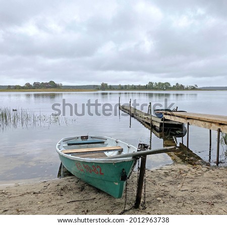 Rowing boat on the shores of Lake Seliger. Walkway on a sandy beach on a cloudy day 