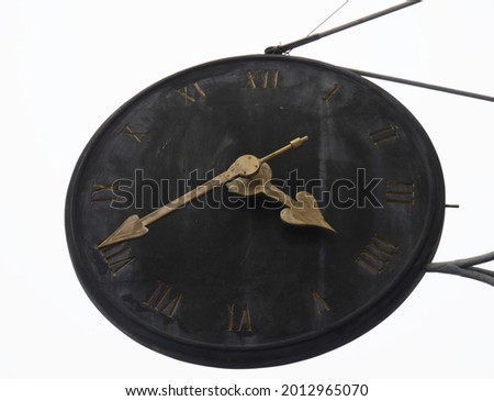 Old black clock with Roman numerals, white background