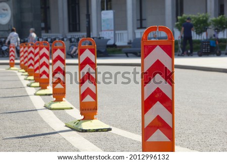 Orange road dividers. Curved line of dividing posts on the double road marking line.