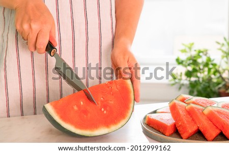 Woman cutting watermelon stock photo