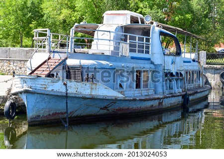 An old rusty boat is moored at the pier of the city. Voronezh. Russia. July 2021