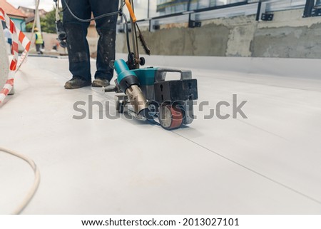 Worker welding pvc  membrane by heater with welder machine Royalty-Free Stock Photo #2013027101