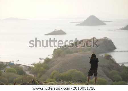 A photographer is taking pictures of the beautiful scenery from the hills.