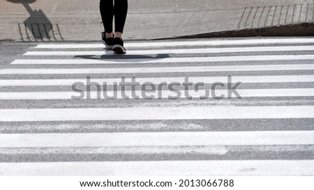 A woman crossing a street in a cross walk