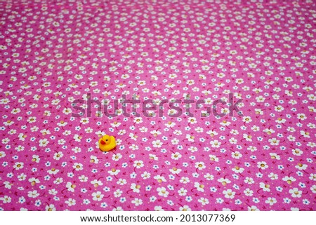 baby duck toy is on a flower-patterned cloth