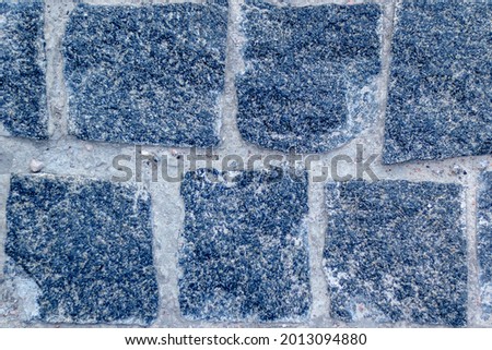 Old natural stone wall on background. Brick wall with ancient masonry. Full frame of rich and varied texture close up.