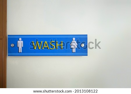 Washroom and toilet sign for both men and women attached on the wall.