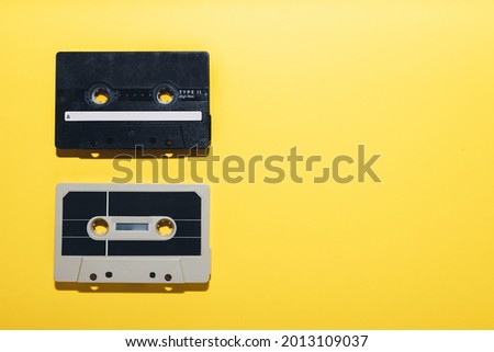 Two audio cassette tapes isolated on a yellow background. Copy space