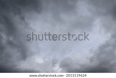 A photograph of the sky with cloud gathered together. Because of the storm and it's about to rain, it looks white and gray with very strong wind. Ideas for climate images and background.