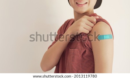 teen boy showing his arm with blue bandage after got vaccinated or  inoculation, child immunization, covid delta vaccine concept